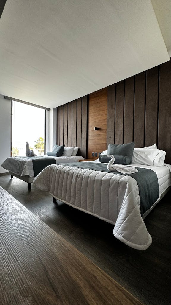 Contemporary hotel room with two beds and elegant decor in León, Mexico.